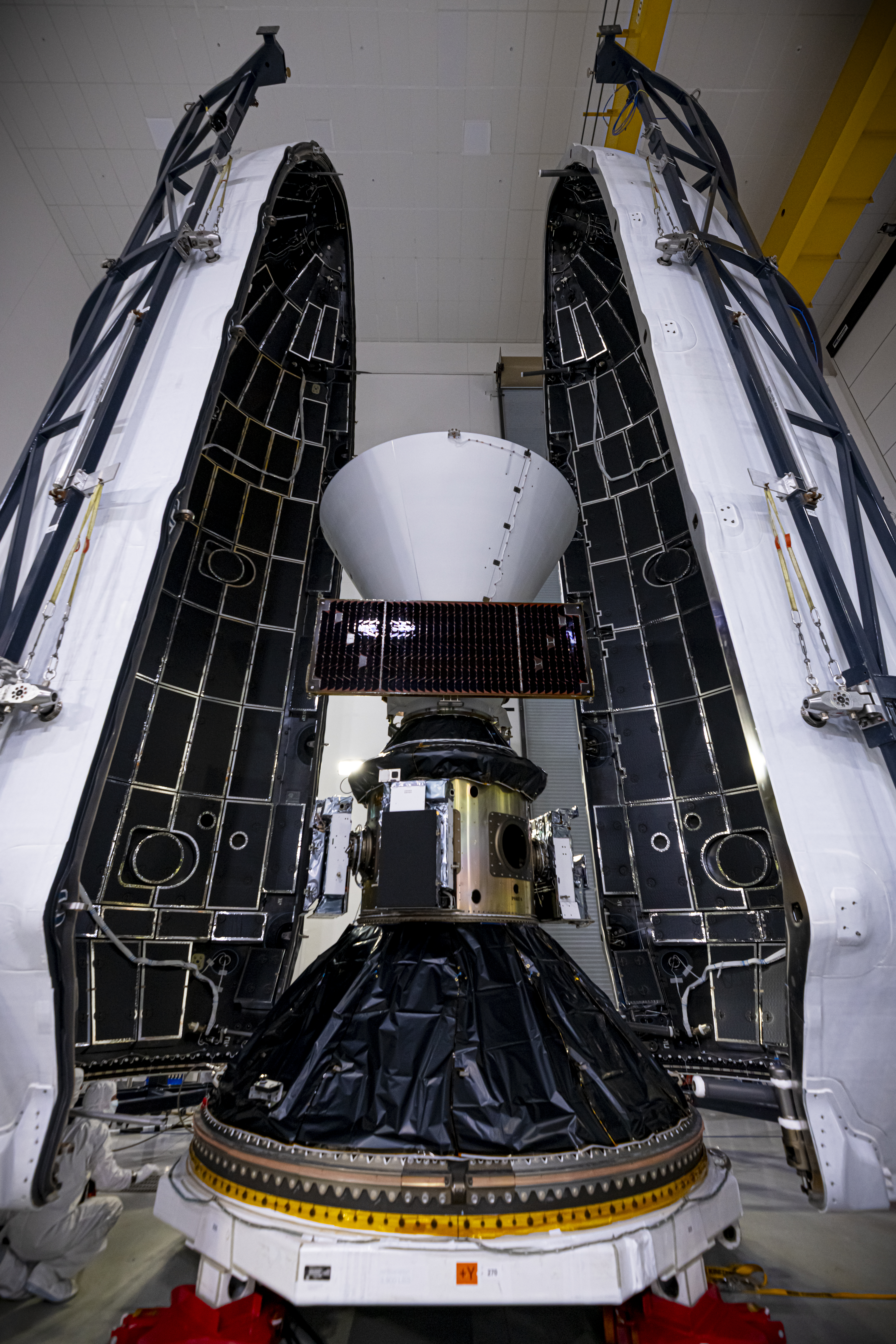 Technicians and engineers encapsulate NASA’s SPHEREx (Spectro-Photometer for the History of the Universe, Epoch of Reionization and Ices Explorer) observatory and PUNCH (Polarimeter to Unify the Corona and Heliosphere) satellites within a protective payload fairing inside the Astrotech Space Operations facility at Vandenberg Space Force Base in California, on Thursday, Feb. 27, 2025.   SPHEREx will use its telescope to provide an all-sky spectral survey, creating a 3D map of the entire sky to help scientists investigate the origins of our universe. PUNCH will study origins of the Sun’s outflow of material, or the solar wind, capturing continuous 3D images of the Sun’s corona and the solar wind’s journey into the solar system. Liftoff aboard a SpaceX Falcon 9 rocket is targeted for NET 10:09 EST (7:09 p.m. PST), Tuesday, March 4, 2025, at Space Launch Complex 4 East from Vandenberg Space Force Base in California. 