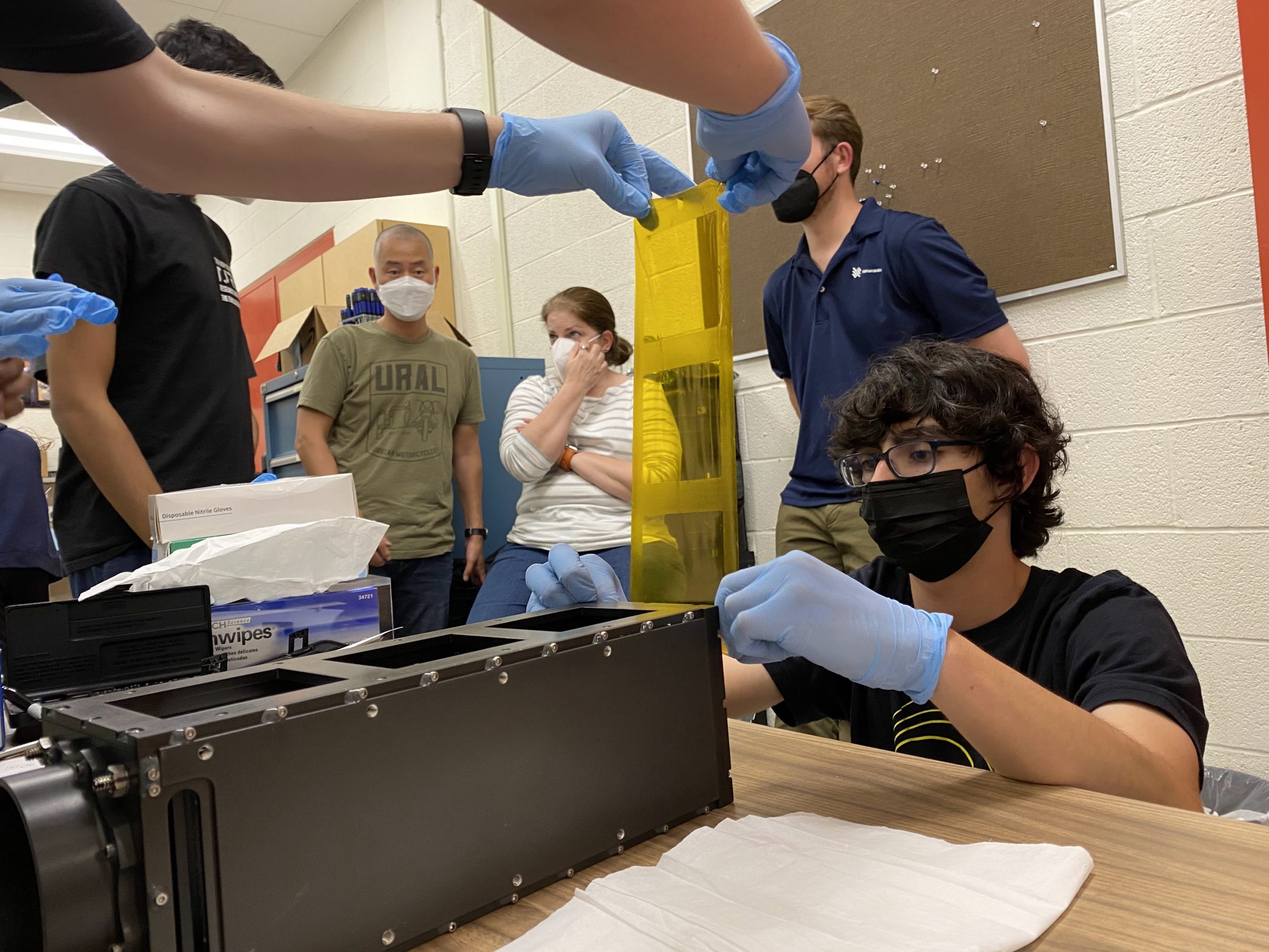 A group of high school students work on their CubeSat, TJREVERB.