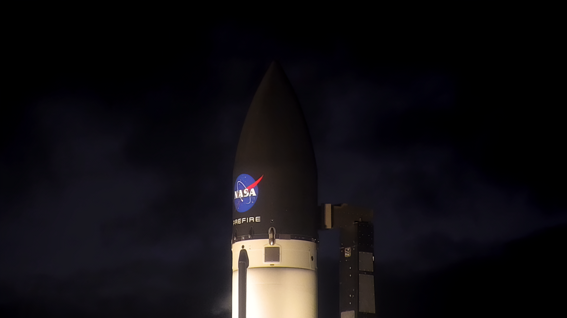 Night shot of Rocket Lab payload fairing with NASA logo and PREFIRE mission name painted on it.