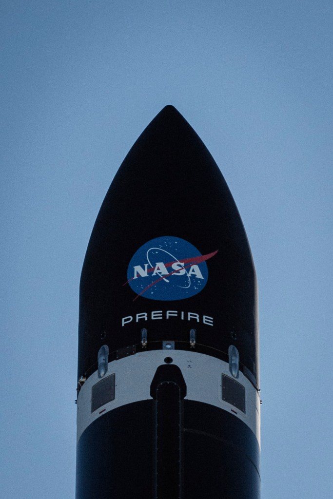 a close up of Rocket Lab's payload fairing while it sits on the launch pad. Painted on it our the NASA logo and the PREFIRE mission name.