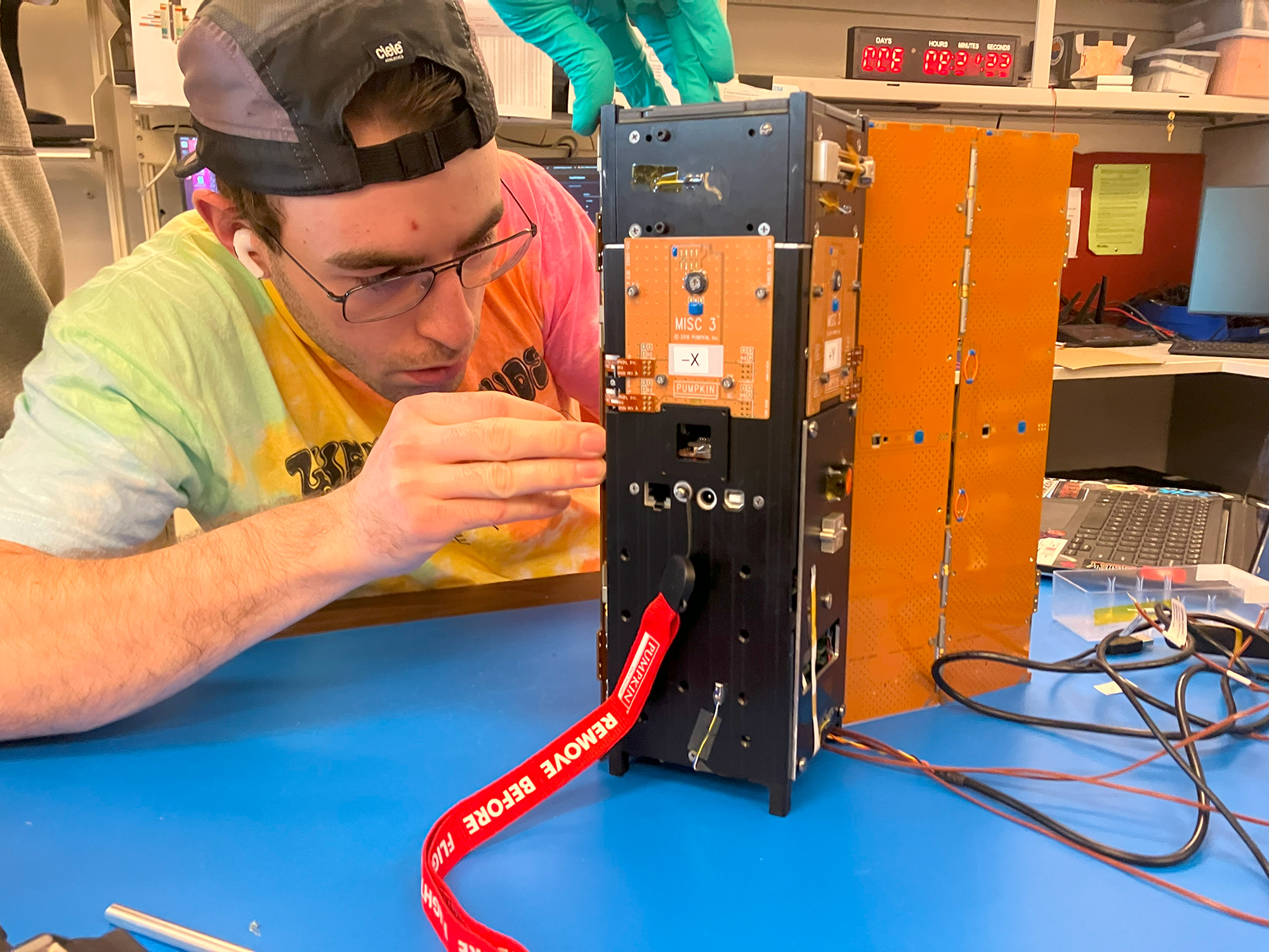 Image shows Arizona State University student Marco Lalonde stows the DORA solar panels in preparation for flight