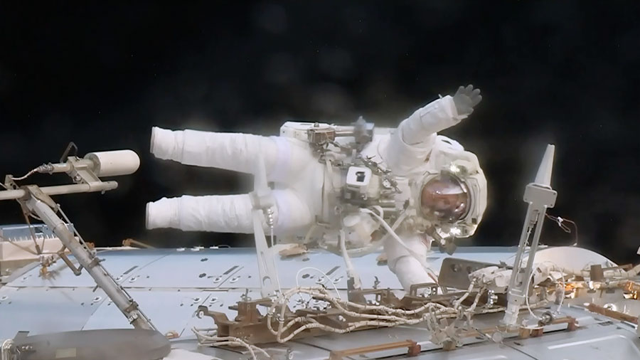 Astronaut Jack Fischer waves while attached to the Destiny laboratory during a spacewalk to replace a failed data relay box and install a pair of wireless antennas.