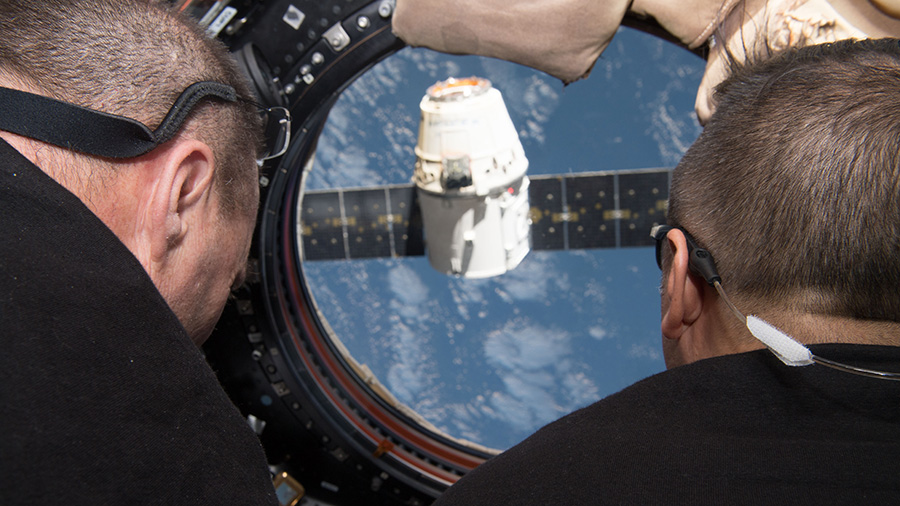 Flight Engineers Scott Tingle and Joe Acaba monitor the departure of the SpaceX Dragon