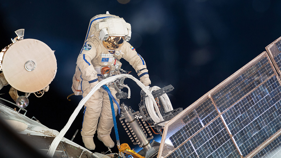 Roscosmos cosmonaut Sergey Prokopyev lays cable on the Zvezda service module during a spacewalk on Aug. 15, 2018.