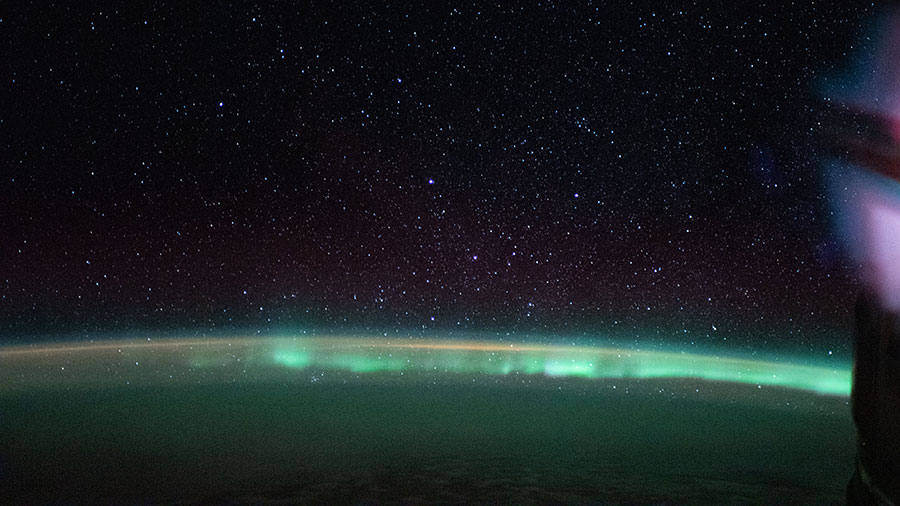 The aurora australis, or "southern lights," highlights a starry nighttime orbital pass