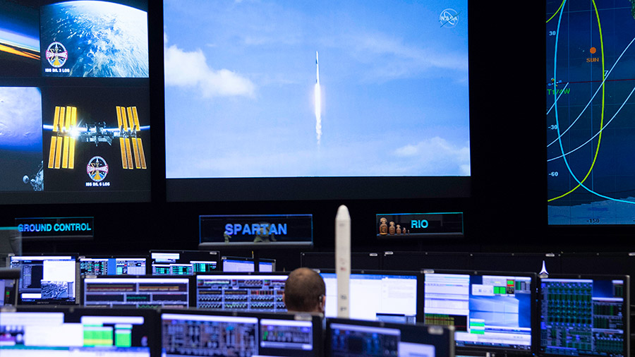 Mission Controllers watch SpaceX Dragon launch