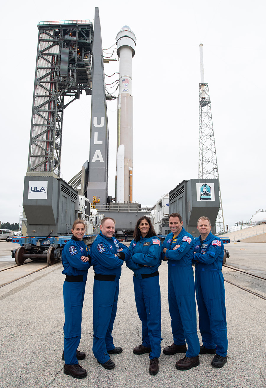 NASA astronauts pose with Boeing’s CST-100 Starliner spacecraft behind them 