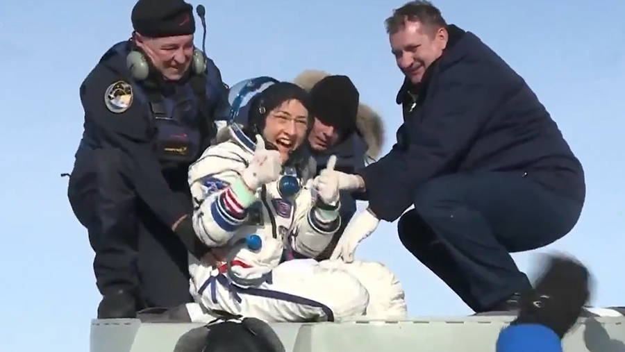 Astronaut Christina Koch smiles as she gives a "thumbs up" sign