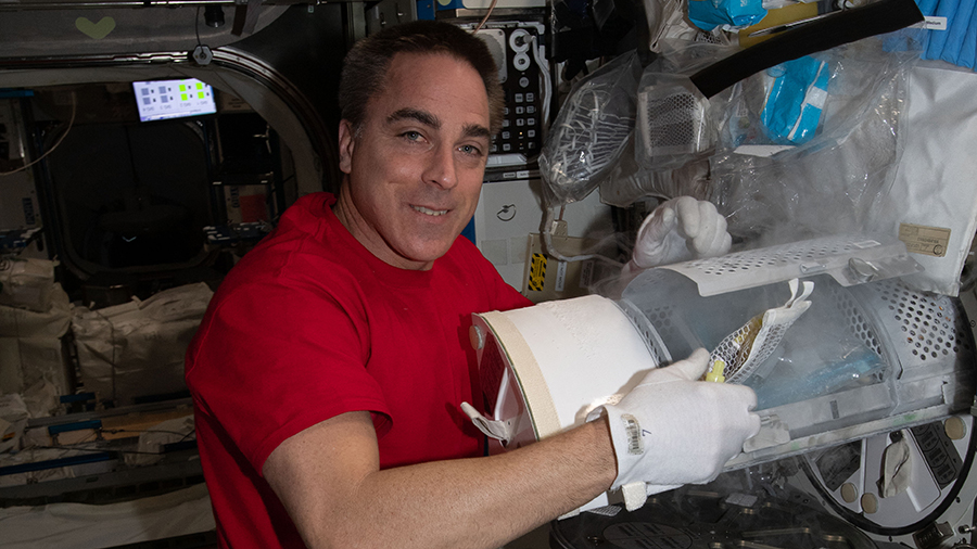 Expedition 63 Commander Chris Cassidy prepares to stow biological samples for preservation inside a science freezer.