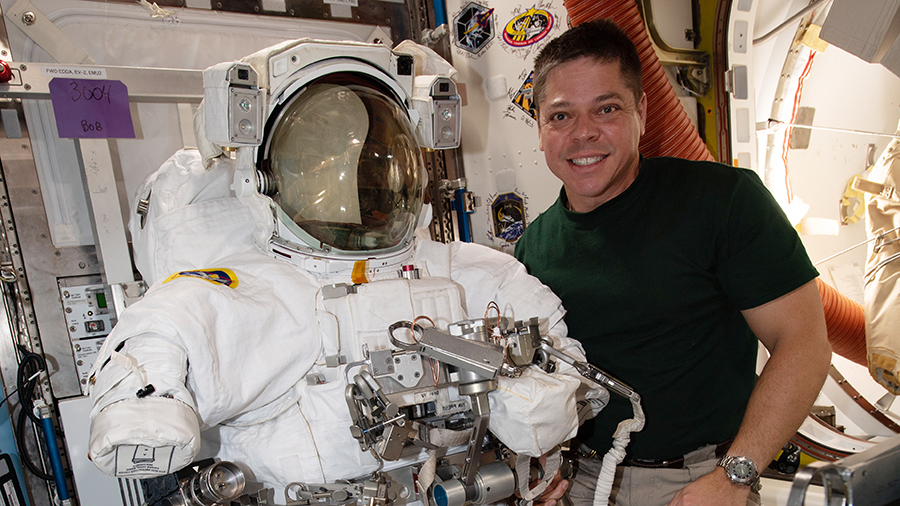 Expedition 63 Flight Engineer Bob Behnken poses with a U.S. spacesuit