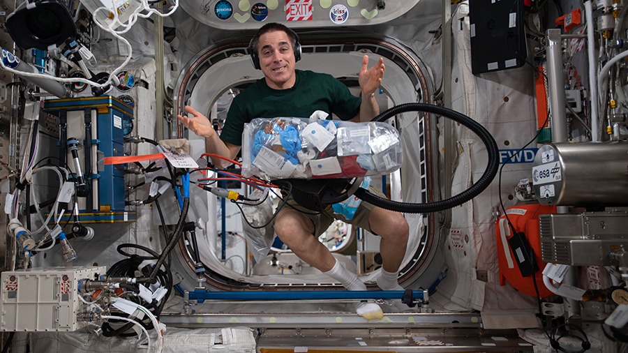 Expedition 63 Commander Chris Cassidy collects trash for disposal during weekend housekeeping activities aboard the space station.