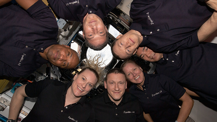 The seven-member Expedition 64 crew gathers together for a New Year's Day portrait inside the International Space Station's "window to the world," the cupola.