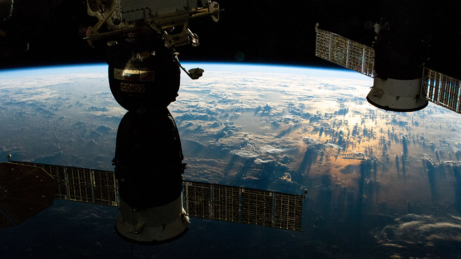 (From left) A Russian crew ship and a Russian cargo craft are pictured docked to the station as it orbited into a sunrise above the South Pacific.