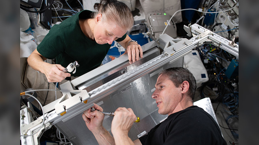 NASA Flight Engineers Shannon Walker and Michael Hopkins install temporary sleeping quarters inside the Columbus laboratory module from the European Space Agency.