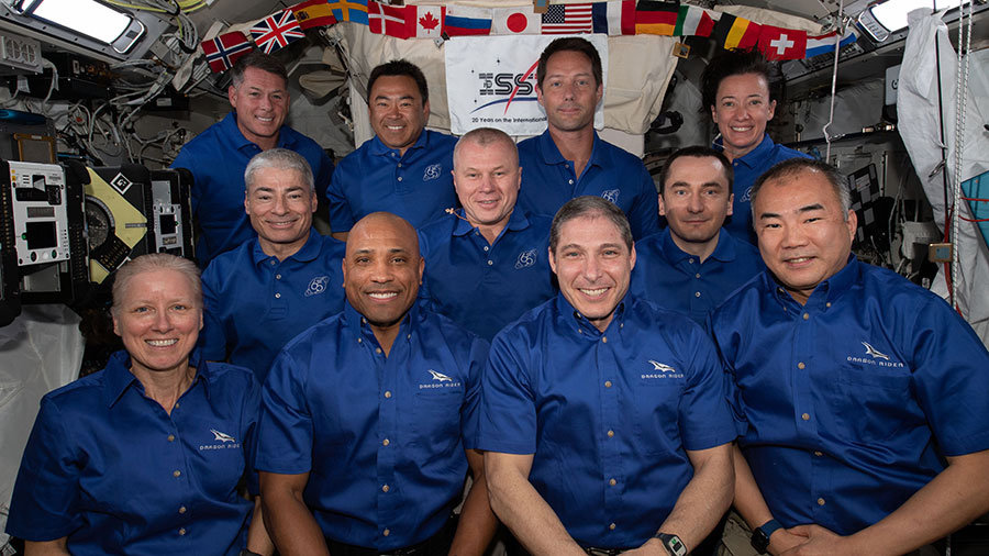 The 11-member crew aboard the station is actually a combination of three different crews. The four Space Crew-2 astronauts are in the back row. The three-person crew of the Soyuz MS-18 crew ship are in the middle row. In the front row is the SpaceX Crew-1 foursome.