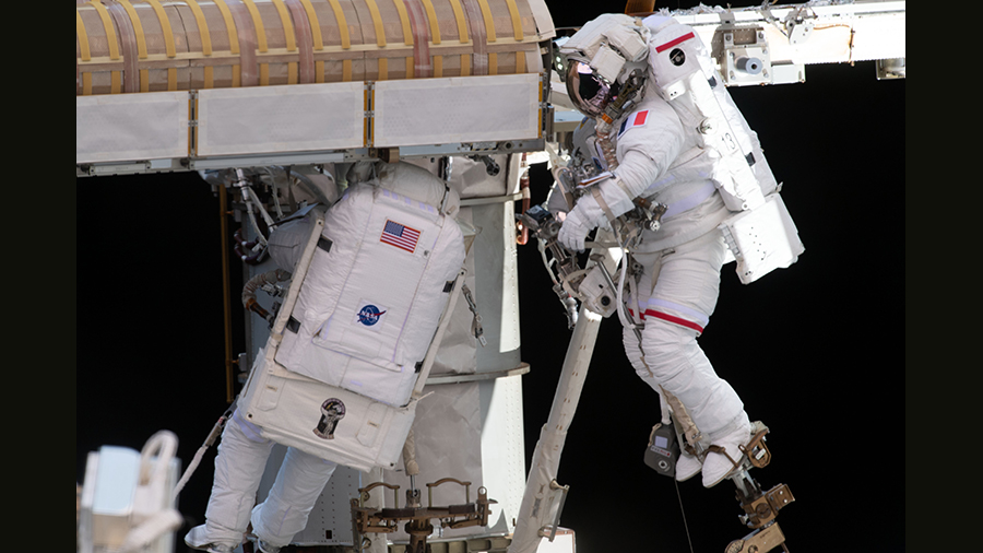 Spacewalkers (from left) Shane Kimbrough and Thomas Pesquet work to complete the installation of a roll out solar array on June 20, 2021,