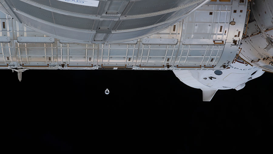 The SpaceX Cargo Dragon vehicle approaches the space station on June 5, 2021. At center right, the SpaceX Crew Dragon spacecraft is also pictured docked to the Harmony module.