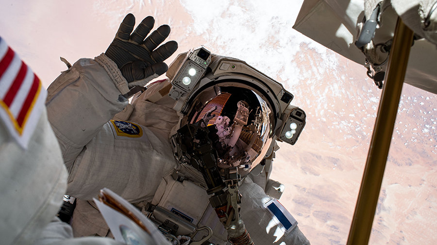 Astronaut Thomas Pesquet waves to the camera during a spacewalk to install Roll-Out Solar Arrays on June 25, 2021.