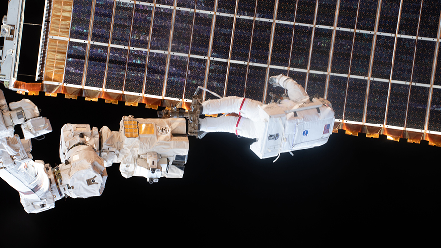 Spacewalker Thomas Pesquet is attached to the tip of the Canadarm2 robotic arm to install the station's second new solar array on June 25, 2021.