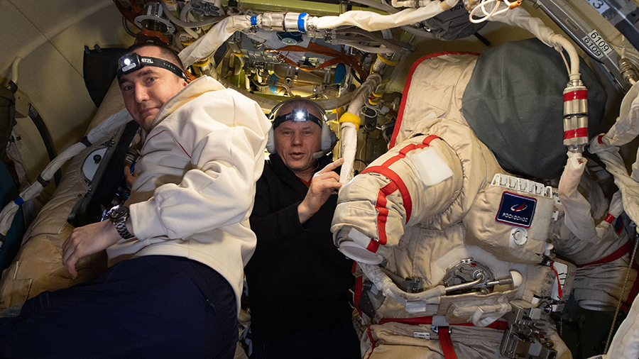 Cosmonauts (from left) Pyotr Dubrov and Oleg Novitskiy prepare Russian Orlan spacesuits.