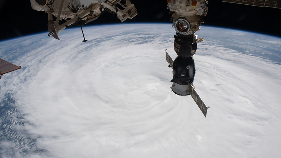 Typhoon Mindulle is pictured 261 miles below the space station on Oct. 1, 2021. The Soyuz MS-18 crew ship (foreground) is docked to the Nauka multipurpose laboratory module.