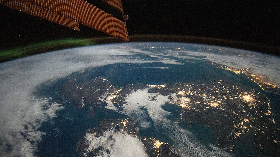 A faint aurora and the Earth's atmospheric glow are pictured above the city lights of Ireland and Great Britain from the space station.