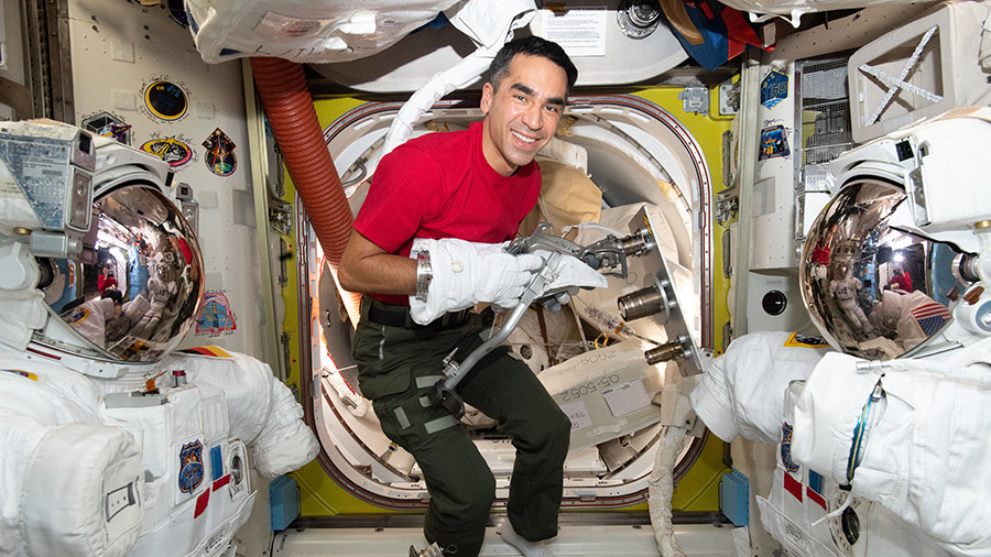 Astronaut Raja Chari tests using tools while wearing a spacesuit glove inside the space station's U.S. Quest airlock.