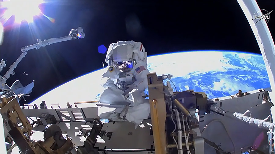 NASA astronaut Kayla Barron works to ready the space station for a third set of roll-out solar arrays about 260 miles above the Earth. Credit: NASA TV