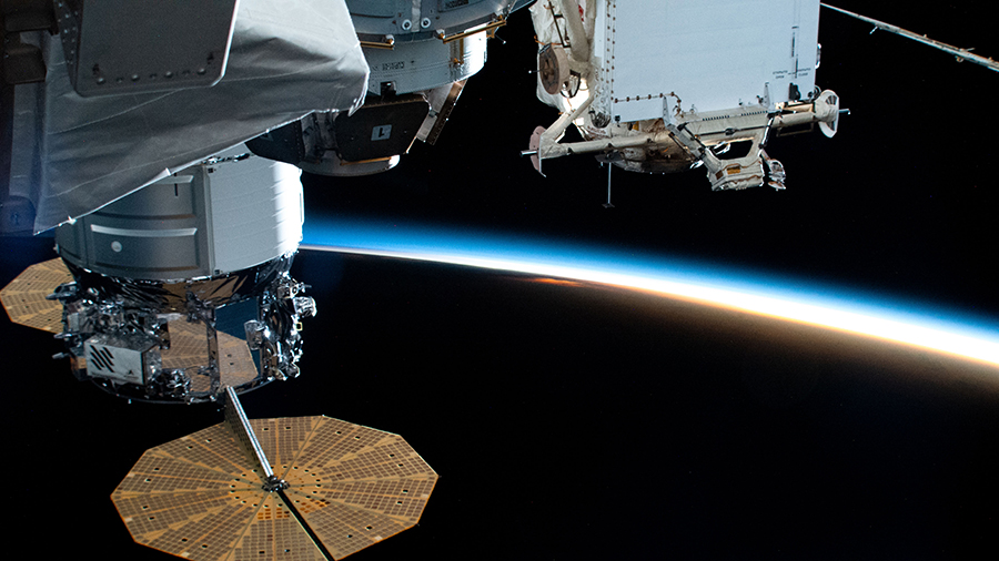 The space station with the Cygnus space freighter (left) attached orbits into a sunset 261 miles above the Pacific Ocean.