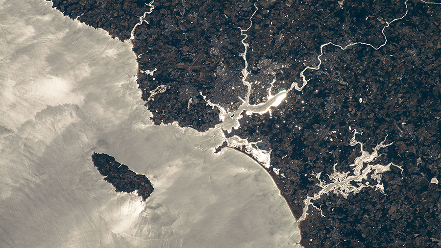 The island of Groix is pictured off the northwestern coast of France with the Atlantic Ocean beaming from the sun's glint.