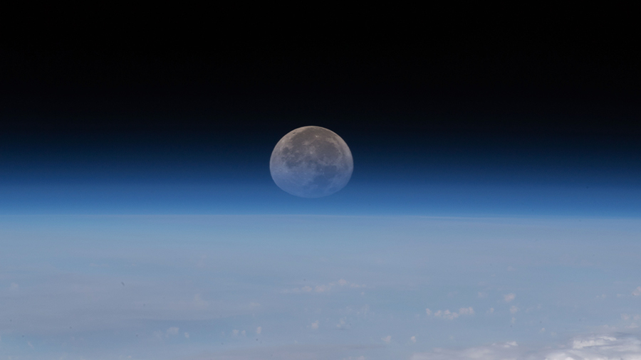 As the Moon sets below Earth's horizon the atmosphere refracts, or bends, its light making it appear flatter in this photograph taken from the space station.