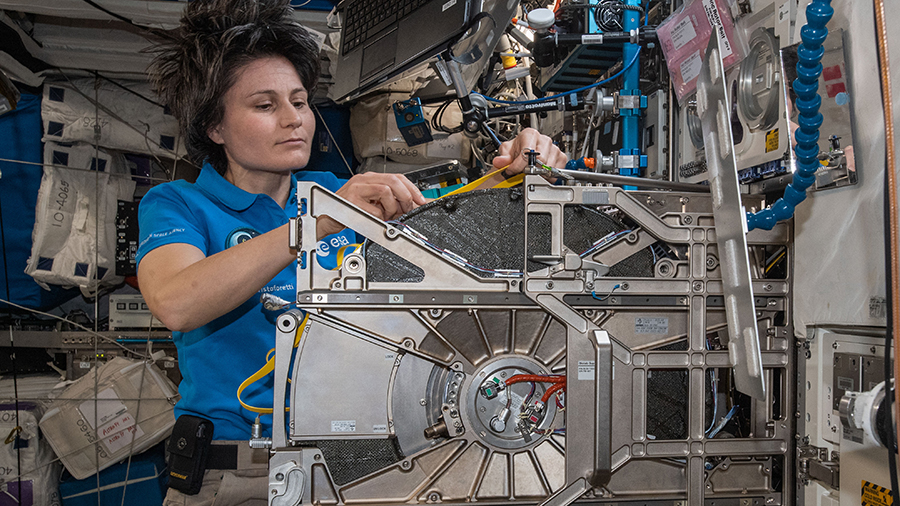 Astronaut Samantha Cristoforetti replaces centrifuge components inside the Columbus laboratory module's BioLab.