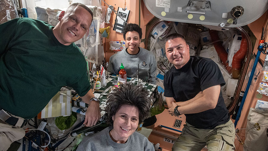 Expedition 67 astronauts (clockwise from left) Bob Hines, Jessica Watkins, Kjell Lindgren, and Samantha Cristofroetti pose for a portrait during dinner time aboard the space station.