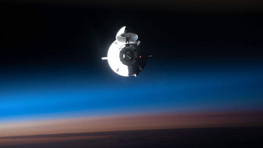 The SpaceX Dragon space freighter approaches the space station during an orbital sunrise on July 16, 2022.