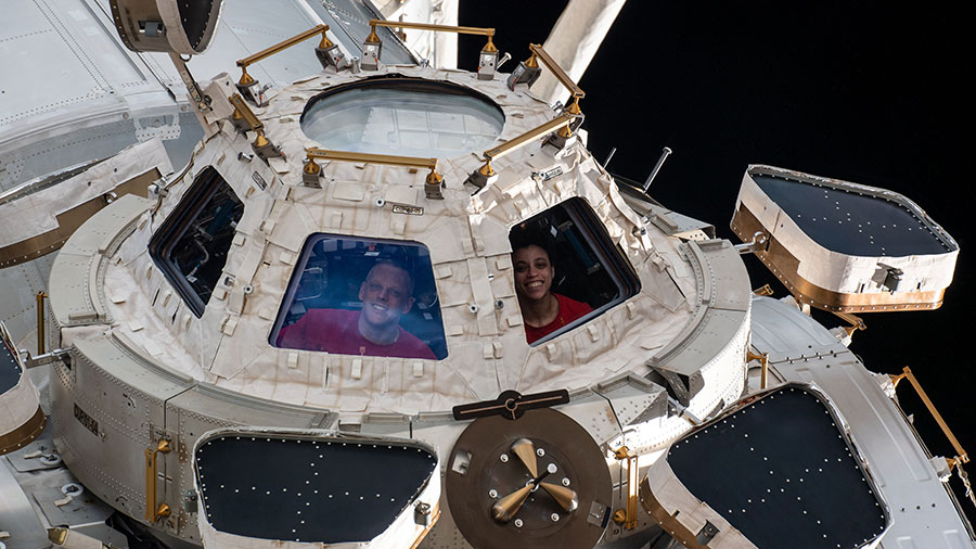 NASA astronauts Bob Hines and Jessica Watkins look out from a window on the cupola, the International Space Station's "window to the world."