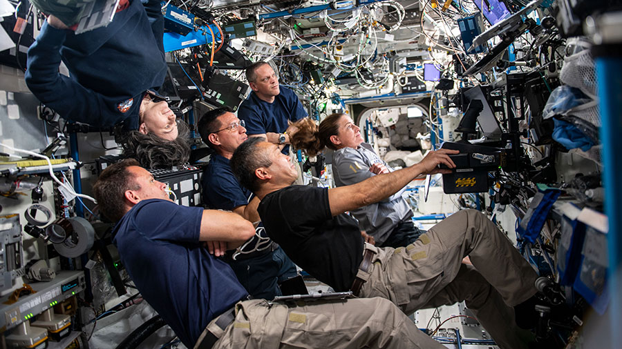 Expedition 68 crew members participate in a conference with mission controllers on the ground before the departure of the SpaceX Crew-4 astronauts.