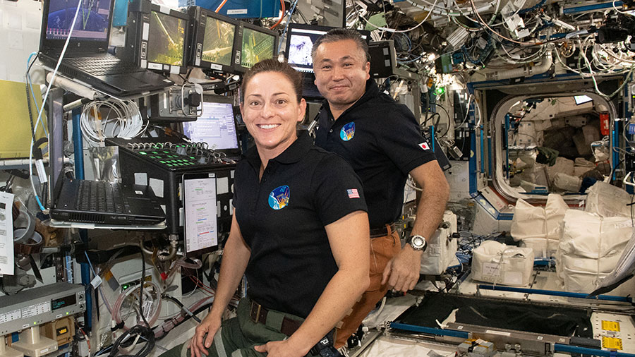 Astronauts Nicole Mann and Koichi Wakata are pictured at the robotics workstation that controls the Canadarm2 robotic arm from inside the space station's Destiny laboratory module.