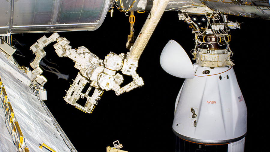 The SpaceX Dragon cargo craft, with its nose cone open, is pictured docked to the space-facing port on the space station's Harmony module.