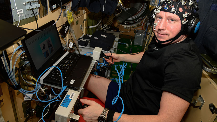 Commander Sergey Prokopyev wears a head cap with sensors and practices potential piloting techniques for futuristic planetary missions.