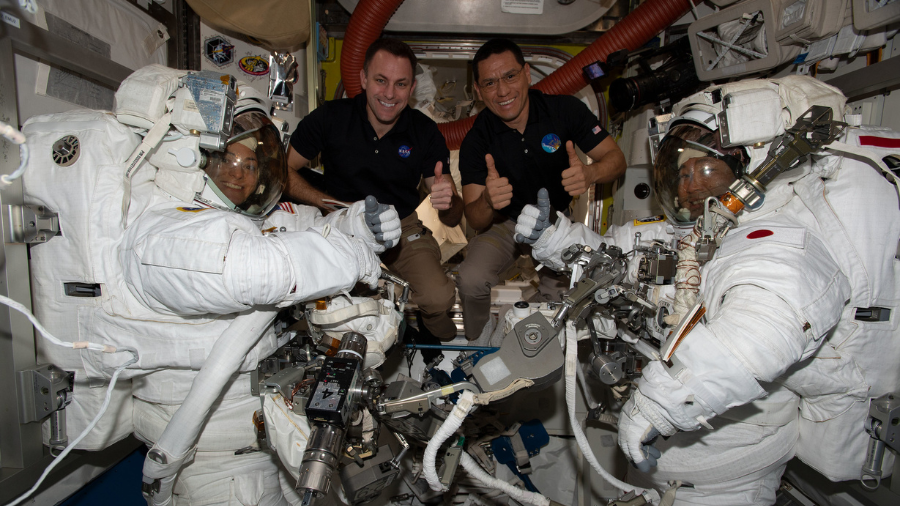 Expedition 68 Flight Engineers (middle left to right) Josh Cassada and Frank Rubio, both from NASA, pose with astronauts (far left and right) Nicole Mann from NASA and Koichi Wakata of the Japan Aerospace Exploration Agency (JAXA) in their Extravehicular Mobility Units (EMUs), or spacesuits, as they prep for a spacewalk on Jan. 20, 2022.