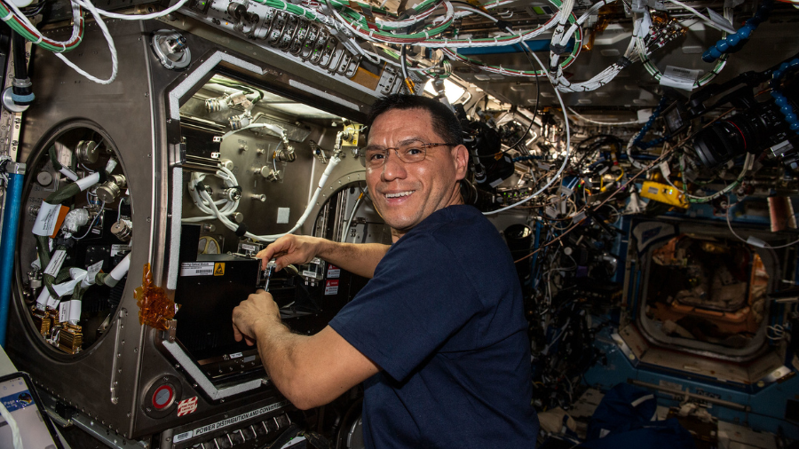 NASA astronaut and Expedition 68 Flight Engineer Frank Rubio sets up the new Particle Vibration experiment inside the Destiny laboratory module’s Microgravity Science Glovebox on Feb. 3, 2023. The physics study will investigate how particles organize themselves in fluids possibly advancing manufacturing techniques and providing new insights on astrophysics.