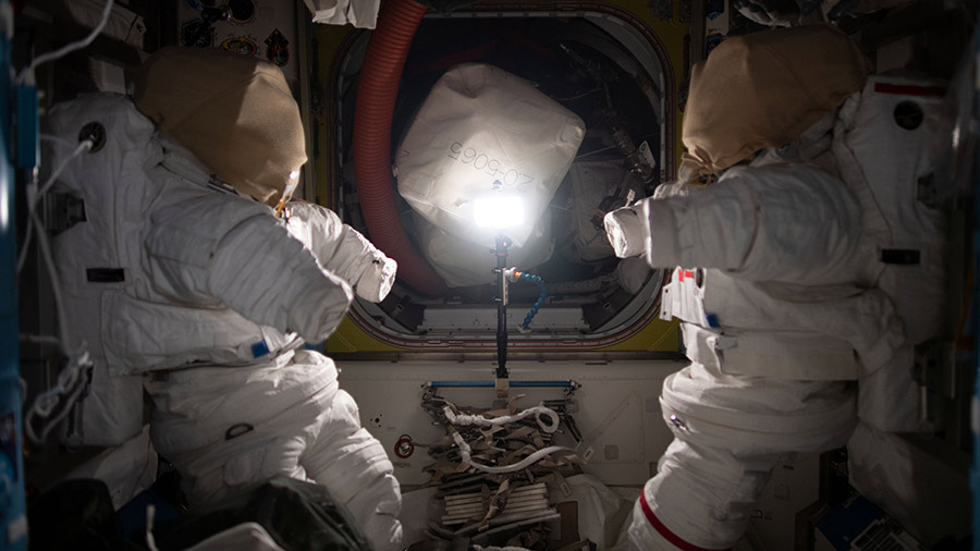 A pair of Extravehicular Mobility Units (EMUs), also known as spacesuits, are pictured inside the space station's Quest airlock where spacewalks are staged by astronauts wearing the EMUs.