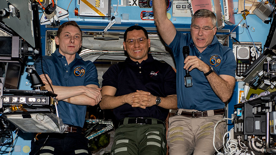 NASA astronauts (from left) Woody Hoburg, Frank Rubio, and Stephen Bowen talk to elementary and junior high school students on Earth.