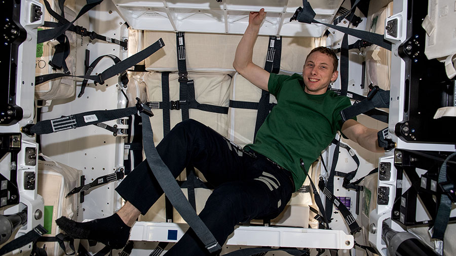 Astronaut Woody Hoburg is pictured loading cargo inside the SpaceX Dragon cargo spacecraft.