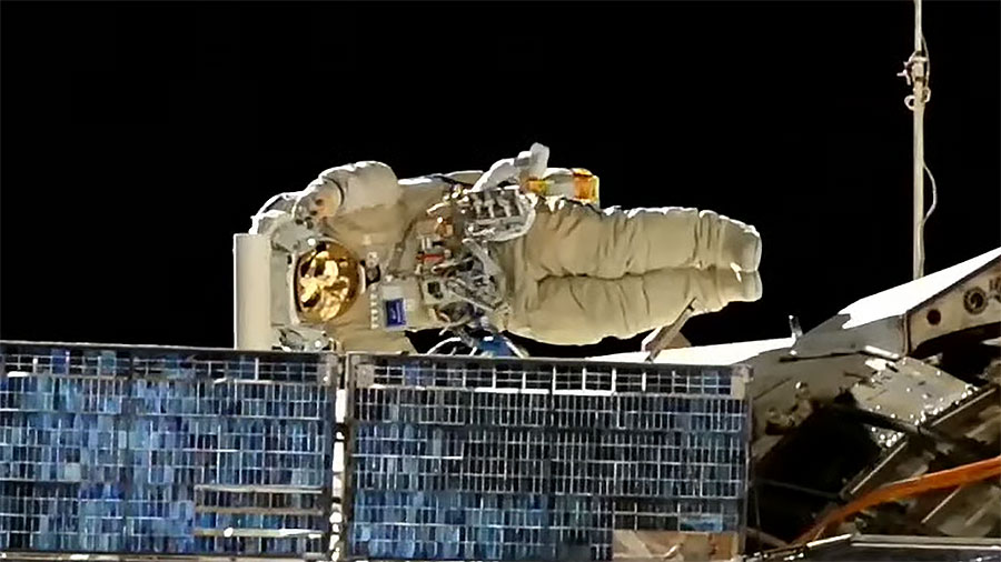 Cosmonaut Dmitri Petelin is pictured behind a solar array during a spacewalk to remove and replace science and communications hardware on the Roscosmos' segment of the International Space Station. Credit: NASA TV