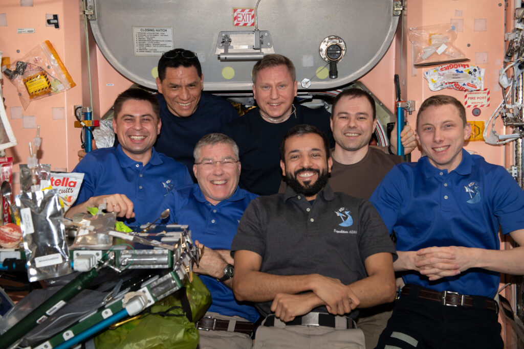 The seven-member Expedition 69 crew poses for a portrait during dinner time inside the International Space Station's Unity module. From left are, Roscosmos cosmonaut Andrey Fedyaev; NASA astronauts Frank Rubio and Stephen Bowen; Roscosmos cosmonaut Sergey Prokopyev; UAE (United Arab Emirates) astronaut Sultan Alneyadi; Roscosmos cosmonaut Dmitri Petelin; and NASA astronaut Woody Hoburg.