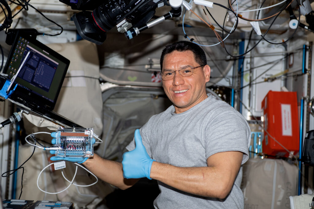 iss069e031305 (July 13, 2023) -- NASA astronaut and Expedition 69 Flight Engineer Frank Rubio poses for a photo as he inspects blankets and blanket covers in crew quarters for future replacements.