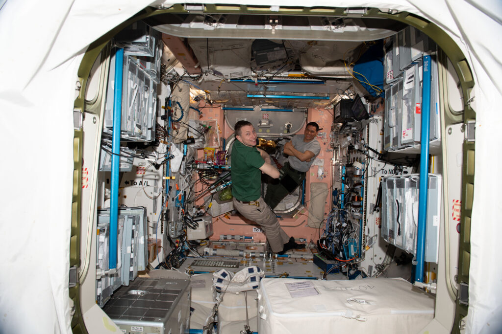 Expedition 69 Flight Engineers (from left) Woody Hoburg and Frank Rubio, both NASA astronauts, are pictured relaxing in the Unity module after an afternoon of orbital plumbing tasks aboard the International Space Station.