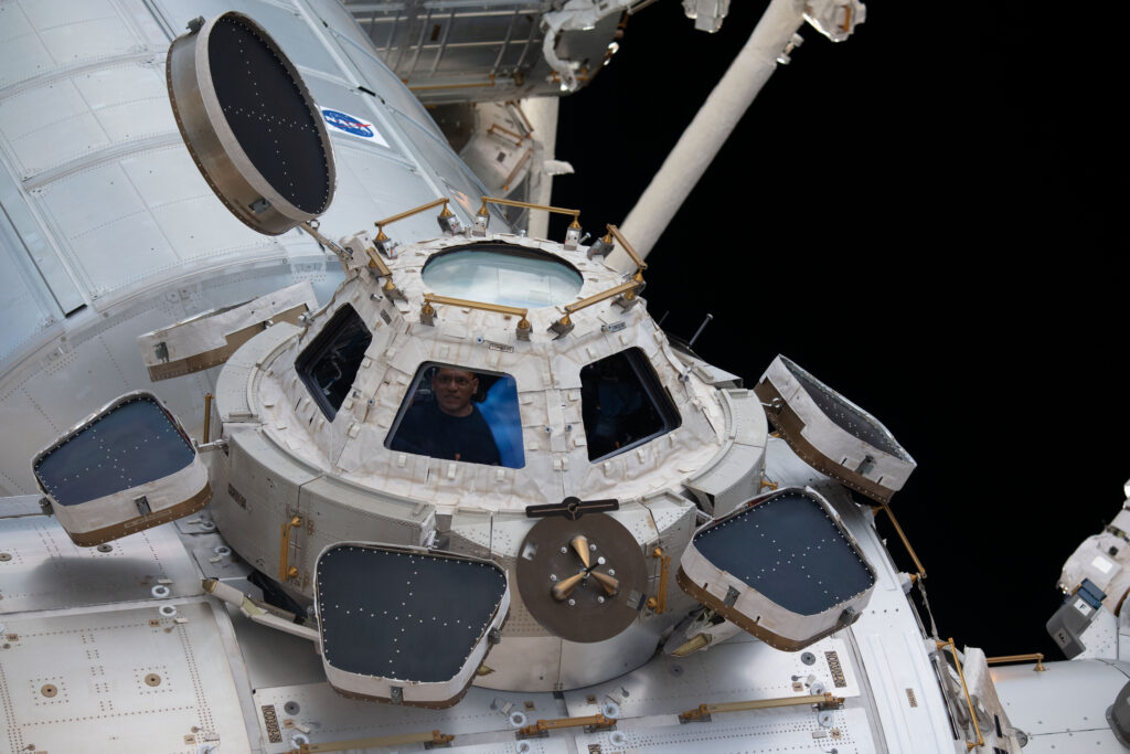 iss068e036064 (Jan. 2, 2023) --- NASA astronaut and Flight Engineer Frank Rubio peers through one of the seven windows in the cupola, the International Space Station's 