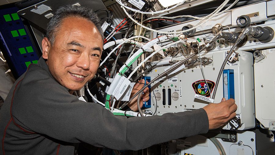 JAXA astronaut Satoshi Furukawa removes experiment hardware from inside the Multi-use Variable-g Platform, a biology research device that can generate artificial gravity.